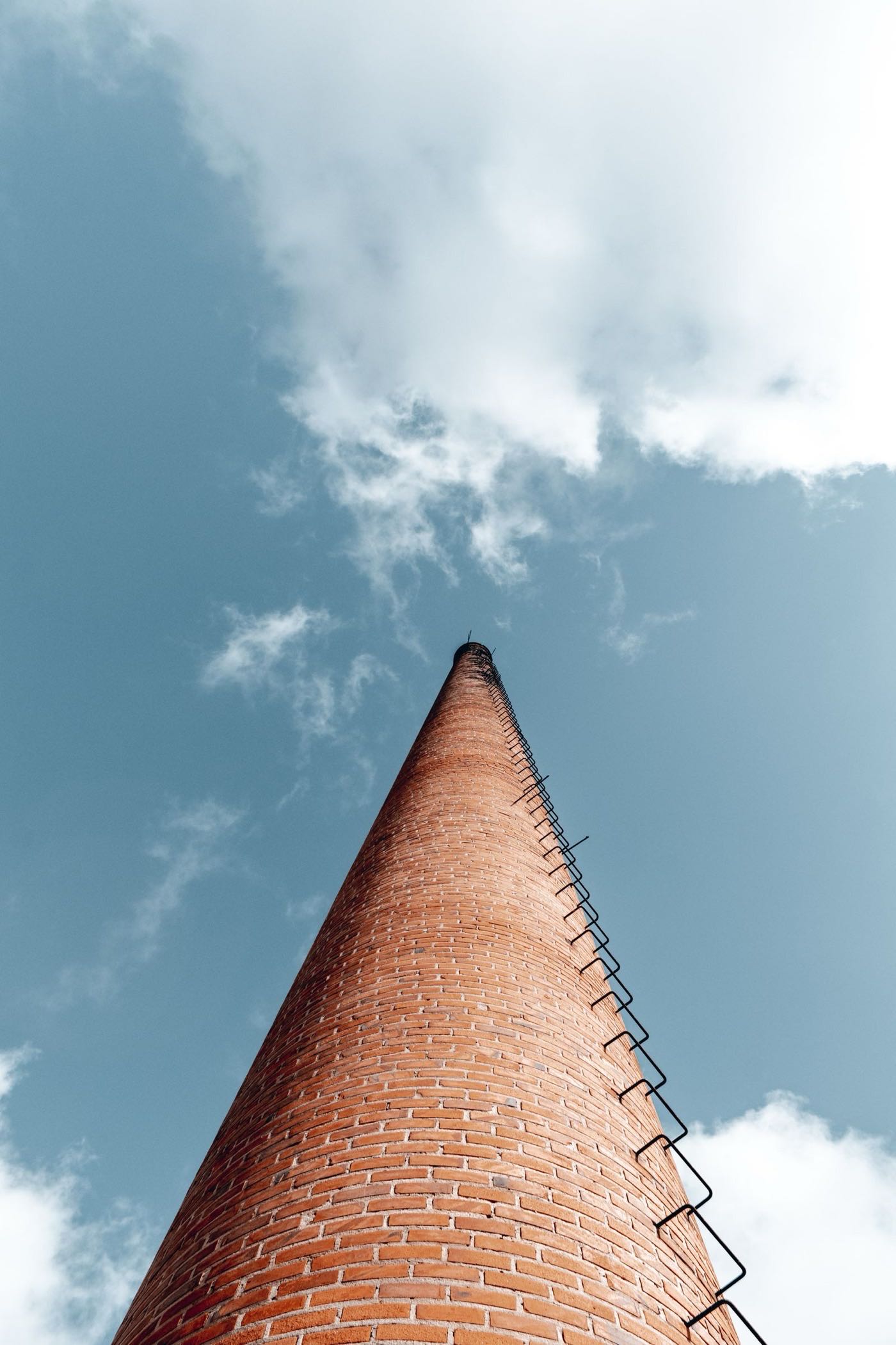 Brick chimney sighted from below — how a lean at the top of the stack first shows itself