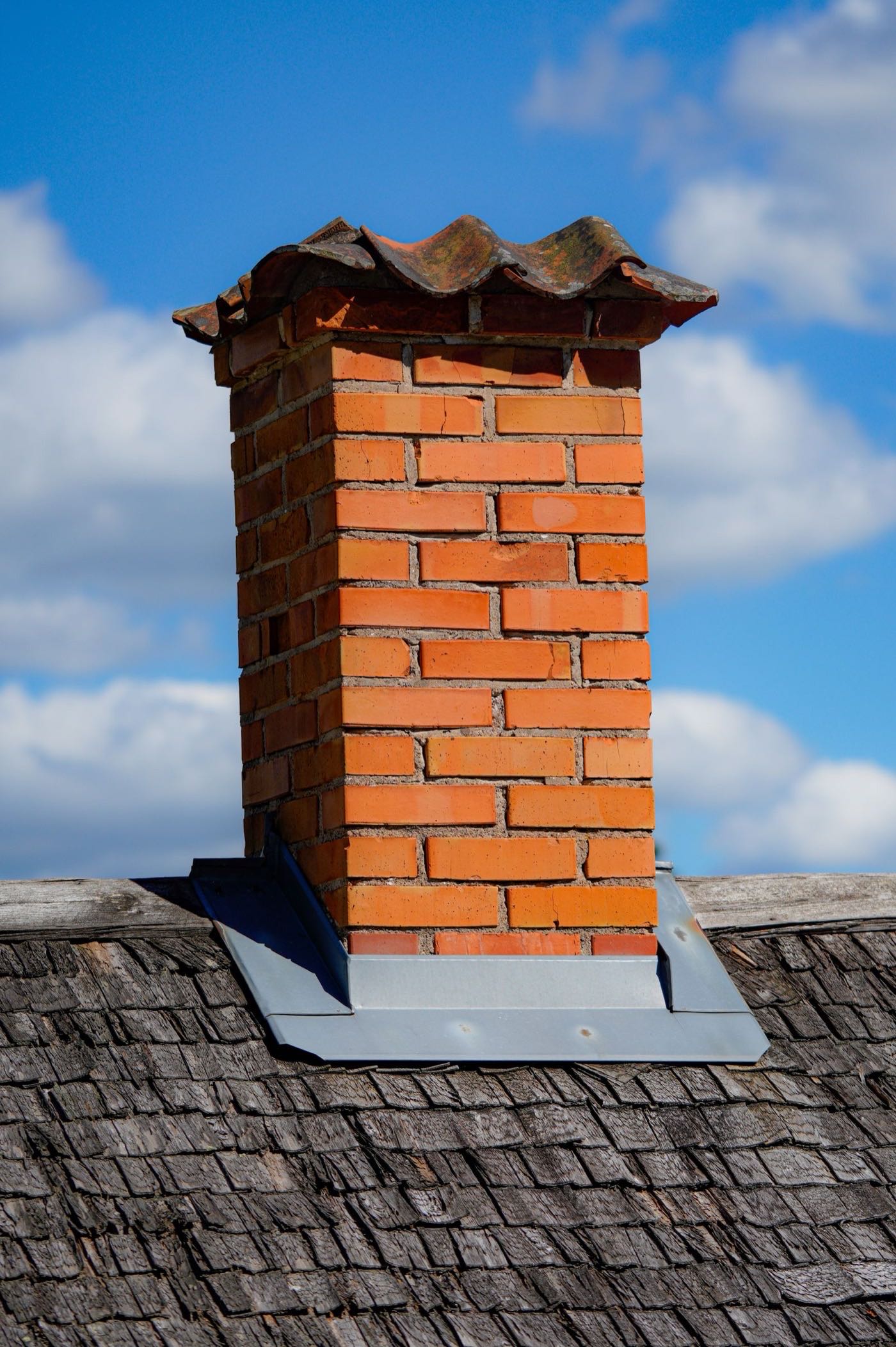 Brick chimney above the shingled roofline of a Moncton-area home on a clear day