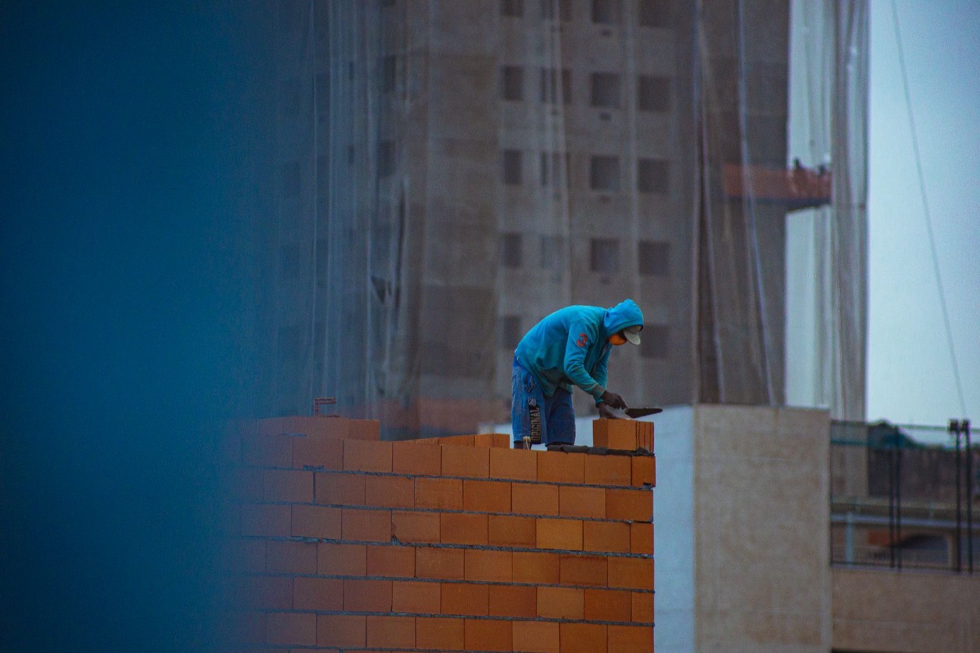 Mason laying fresh courses of brick during a chimney rebuild
